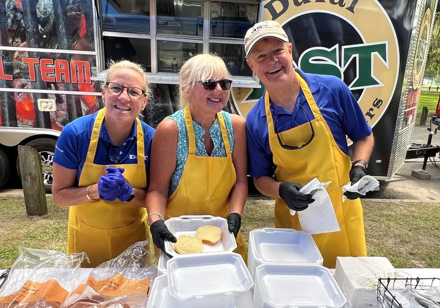 DST Grill Team preparing BBQ at outdoor event.